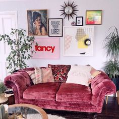 a living room filled with furniture and lots of pictures on the wall above it's couch