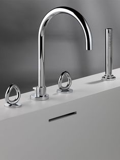 two chrome faucets on a white counter top