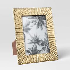 a gold frame with palm trees in the background