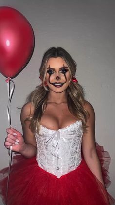 a woman in a costume holding a red balloon