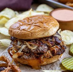 a close up of a hamburger with onion rings