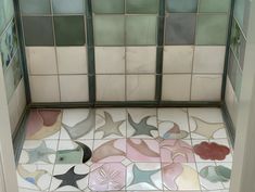 a tiled bathroom with starfish and fish designs on the floor in front of it