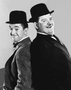 two men in suits and hats are smiling