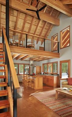 a living room filled with lots of furniture and wooden floors next to a stair case