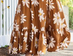 a woman wearing a brown and white flower print dress