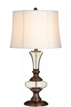 a table lamp with a white shade on it's side and a brown base