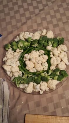 broccoli and cauliflower are arranged in a circular pattern on a table