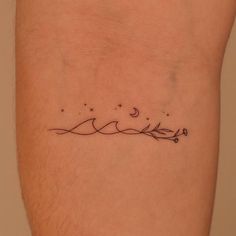 a small tattoo on the leg of a man with stars and moon above it,