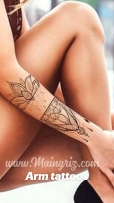 a woman's legs with tattoos on them and her hand resting on the leg