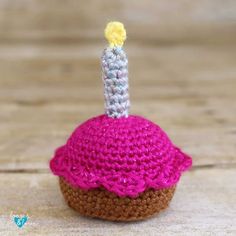 a crocheted cupcake with a small candle sticking out of it's top