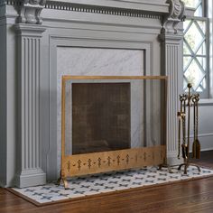 a fireplace in a living room with white walls and wood trimming on the mantle