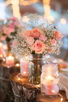 pink roses and baby's breath in a mason jar on a table with candles