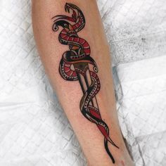 a tattoo on the leg of a person with a snake and dagger in its hand