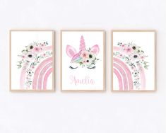 three pink unicorns with flowers and rainbows are hanging on the wall