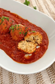 a white bowl filled with meatballs covered in sauce