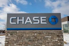 a chase bank sign on top of a stone wall in front of a brick building