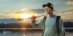 a man holding a fishing rod in front of the sun