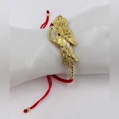 Pulsera Ajustable De Hilo Rojo De La Santa Muerte Baada En Oro De 18k (The Grim Reaper Bracelet). Elaborada Con Exquisita Atencin Al Detalle, Esta Pulsera Presenta Un Diseo De La Muerte Y Es Ajustable Para Adaptarse A Cualquier Tamao De Mueca. Est Baado En Oro Y Su Llamativo Hilo Rojo Aadir Un Toque De Sofisticacin A Cualquier Estilo. Adjustable Red String Bracelet Of La Santa Muerte Plated In 18k Gold (The Grim Reaper Bracelet). Crafted With Exquisite Attention To Detail, This Bracelet Features Bike Chain Bracelet, Deer Antler Ring, Biker Chain, Silver Dimes, The Grim Reaper, Antler Ring, Rock Necklace, Dragon Bracelet, Red String Bracelet