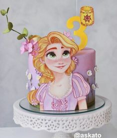 a birthday cake with a princess face and number three on top, sitting on a table