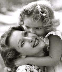 an old black and white photo of two women with one holding the other's head