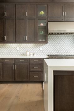 a kitchen with dark wood cabinets and white counter tops