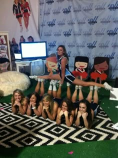 the cheerleaders are posing for a photo in front of a wallpapered backdrop