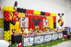 a mickey mouse themed birthday party with balloons and decorations