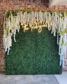 an artificial plant wall with white flowers and the words'the party guests'written on it