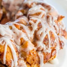 two cinnamon rolls covered in icing on a white plate