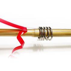 a red ribbon is attached to a gold pen with silver spirals on the end