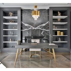 an elegant dining room with gray walls and marbled table in front of the bookshelves