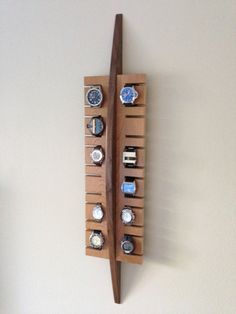 a wooden display with watches on it and a toothbrush hanging from the wall next to it