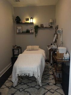 a small room with a bed, desk and shelves on the wall above it that have plants in them