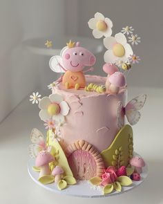 a pink cake decorated with flowers and animals