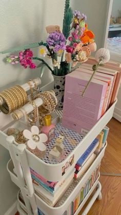 a white cart filled with lots of books and flowers