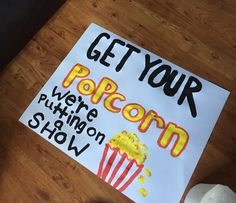 a sign that says get your popcorn we're trying show