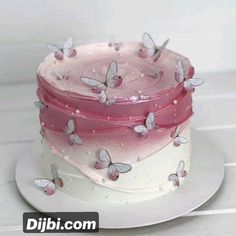 a three layer cake with pink frosting and butterflies on the top, sitting on a white plate