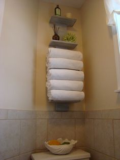 a stack of white towels sitting on top of a toilet