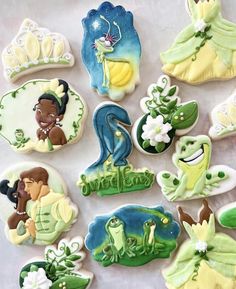 some decorated cookies with princess and the frog characters on them are sitting on a table