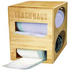 a bamboo trash bag dispenser with two rolls of toilet paper in it