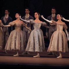 a group of ballerinas standing on top of a stage