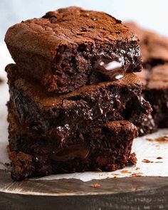 two chocolate brownies stacked on top of each other with one piece cut in half