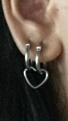 an ear with two silver hoops attached to it's sides and a heart on the side