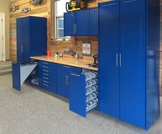 a garage with blue cabinets and tools in it