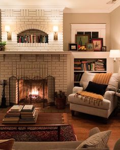 a living room filled with furniture and a fire place next to a book shelf full of books