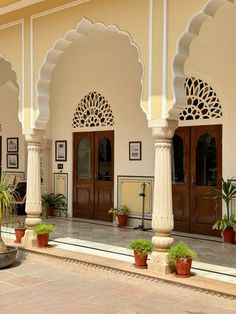 an ornate building with columns and potted plants