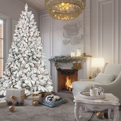 a white christmas tree in a living room with presents on the floor next to it