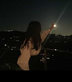 a woman standing on top of a roof at night