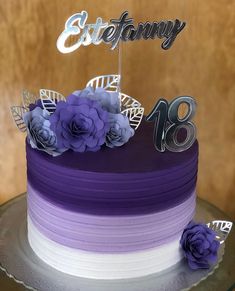 a purple and white cake with flowers on top