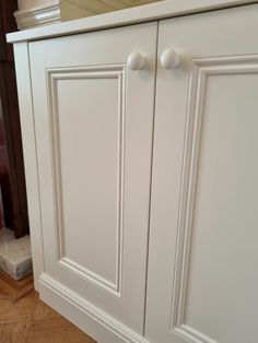 a white cabinet with two knobs on it